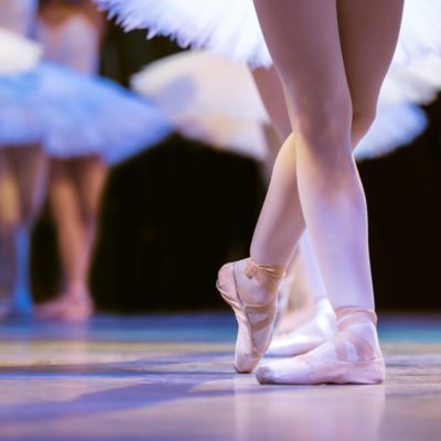 Legs of ballerinas dancing in ballet Swan Lake.